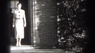1938: woman walking out of her house in a pretty dress. CUMBERLAND MARYLAND