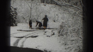 1938: two kids having fun in the snow while being looked after by an adult