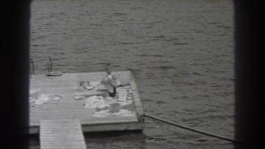 1938: young woman drying herself off with a towel on a dock then running back