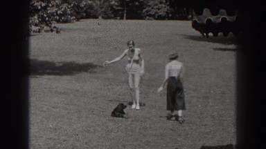 1938: a black dog playing with two ladies on the meadow NEW JERSEY