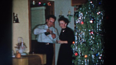 1957: couple indoor beside christmas tree pouring wine WHEELING OHIO