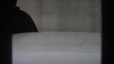 1958: a man walks on a sidewalk and then closes a gate ITALY