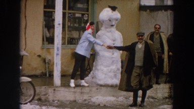 1958: people shaking hands in front of a snowman. ITALY