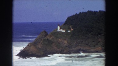 1964: a lighthouse on a tree filled mountain with water around CALIFORNIA