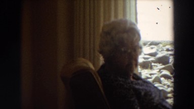 1964: woman sitting alone, watching the ocean from her window. CALIFORNIA