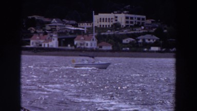 1964: a boat sails down a river near a town at daytime WASHINGTON