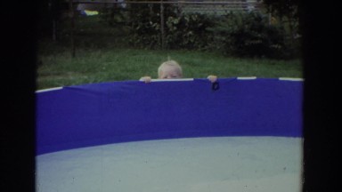 1965: little boy plays peek-a-boo alongside a trampoline. FALLSTON MARYLAND
