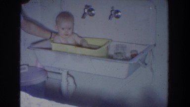 1965: baby getting bathed by an adult in a little tub FALLSTON MARYLAND