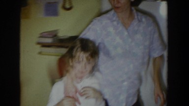 1965: mother and child react excitedly to christmas presents under the tree