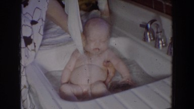 1965: little baby getting a bath in the sink. FALLSTON MARYLAND