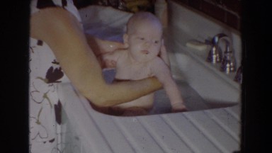 1965: cute baby being bathed by its mother in the sink FALLSTON MARYLAND