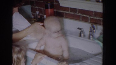 1965: little baby getting a bath in the kitchen sink. FALLSTON MARYLAND