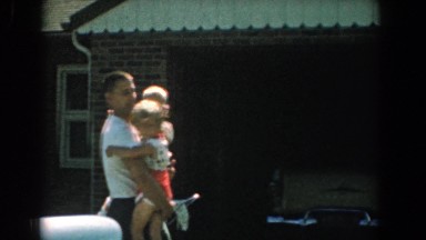 1958: father in the driveway of a home, holding his daughter and son YORKTOWN