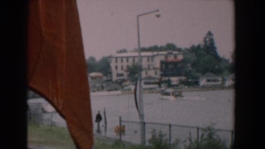 1958: a watercraft enters a harbor at high tide in the summer on a windy day