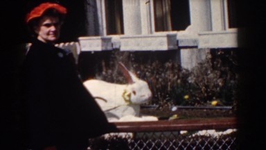 1958: a woman in a hat stands outside next to a house YORKTOWN VIRGINIA