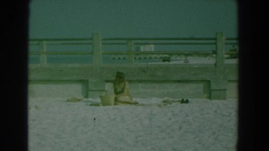 1958: woman sitting in the sand by the beach. YORKTOWN VIRGINIA
