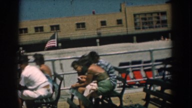 1958: adults waiting on the pier for the tourist boat to load passengers.