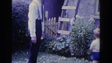 1961: Toddler Watches Family in Garden