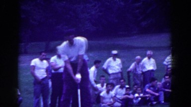 1961: Man Swinging Golf Club and Playing Golf with Crowd Watching