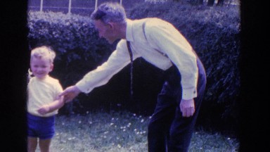 1961: Father Dressed in Suit and Hat Walking with Son Outdoors in Ireland