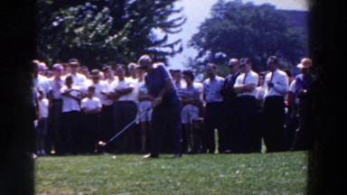 1961: a group of people watching the golf player hitting away the ball