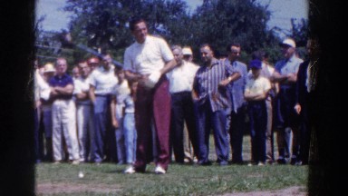 1961: group of people watching a man swing during his turn at golfing