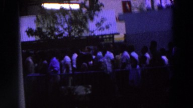 1964: A Large Group of People Standing in Line Behind a Fence