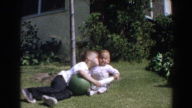 1964: A Little Boy Falls Over Laughing While Kissing His Toddler Sister