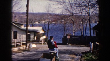 1964: Man Riding Toy Tractor Pulling Small Wagon with Child on Lap