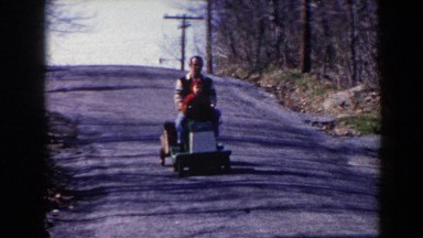 1964: Father and Son Taking a Ride on a Toy Train Down Their Driveway