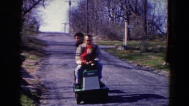 1964: Family Riding Farm Equipment Down a Road Having a Great Time