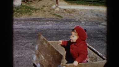 1964: Father Driving Curious Red Vehicle with Child in Box in Pequot Lakes