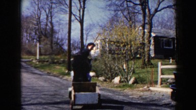 1964: Children Playing on Toy Cart Riding Up Street, Pequot Lakes
