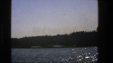 1975: Boat in the Distance Travelling Across a Calm Lake in Denmark