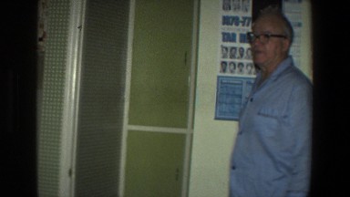 1971: An Elderly Gentleman in a Blue Dress Walking Through a House in Saint Paul