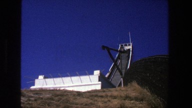 1975: Lookout tower with flags blowing in the wind