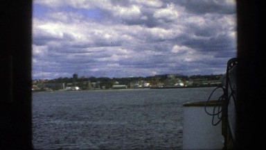 1975: Rope Hanging on a Boat Moving Toward Shore Lined with Buildings