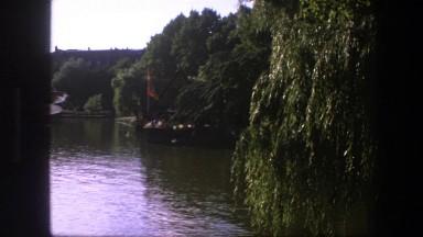 1975: A Red Flag Flying in the Air While Attached to a Metal Pole Outside