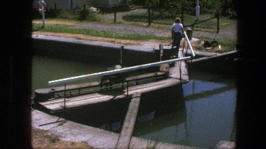 1975: young man walks across bridge over canal in his neighborhood. COPENHAGEN
