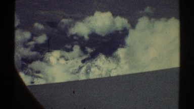 1969: flyover footage of snow capped mountain ridges out the window