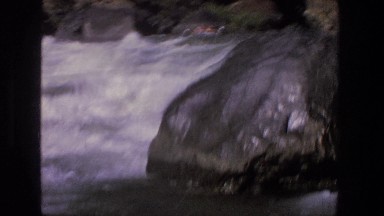 1969: passengers on large inflatable raft approach churning white water