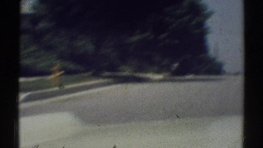 1969: a white car driving down the road with a sidewalk next to it WOODLAND
