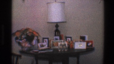 1968: a round table with lot of framed pictures, lamp and flower vase TOLEDO