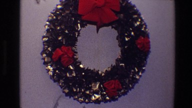 1968: christmas wreath made from metallic loops is decorated with rosettes