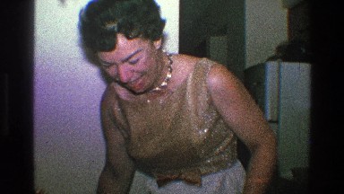 1968: grandmother sitting down to enjoy her family at the dinner table