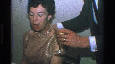 1968: couple kissing at dinner, while having a glass of wine. TOLEDO OHIO