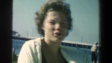 1961: a beautiful young woman standing on the beach removing her cloth BALTIMORE