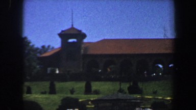 1964: a well-kept lawn, studded with trees, in front of a large building