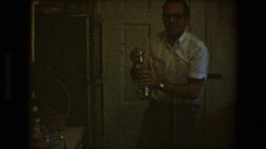 1968: Older Gentleman Holding Two Bottles of Alcohol in Toledo Ohio