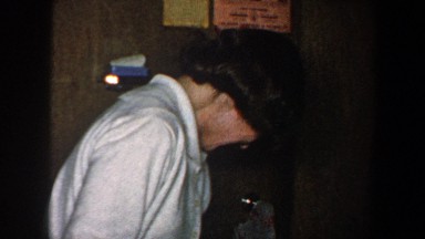1960: two women laughing in a room while picking up a suitcase NEW YORK CITY